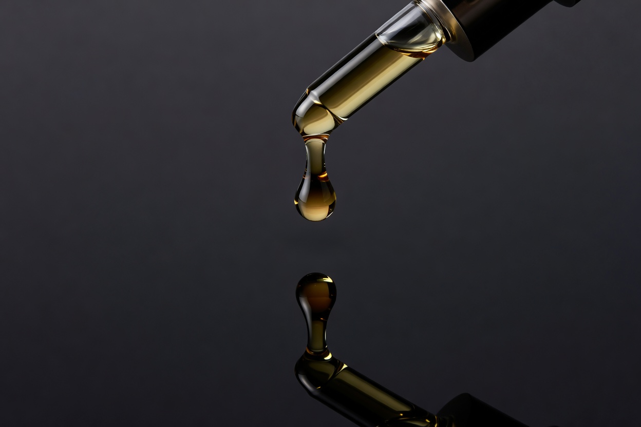 Clinical luxury serum drop suspended above deep obsidian pool